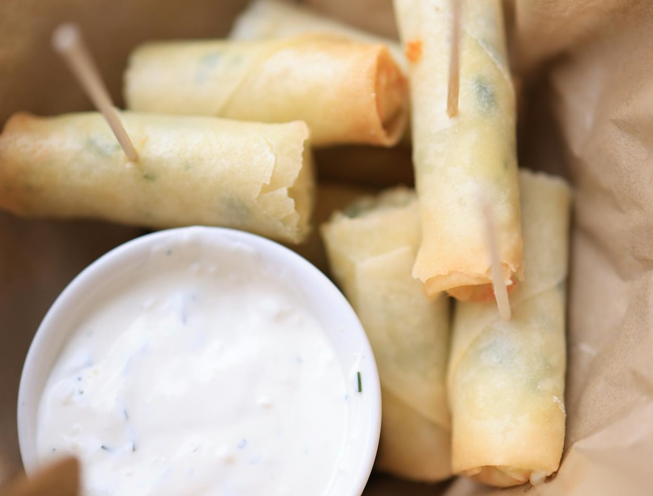 Paper Bag with Spring Rolls and dipping sauce.