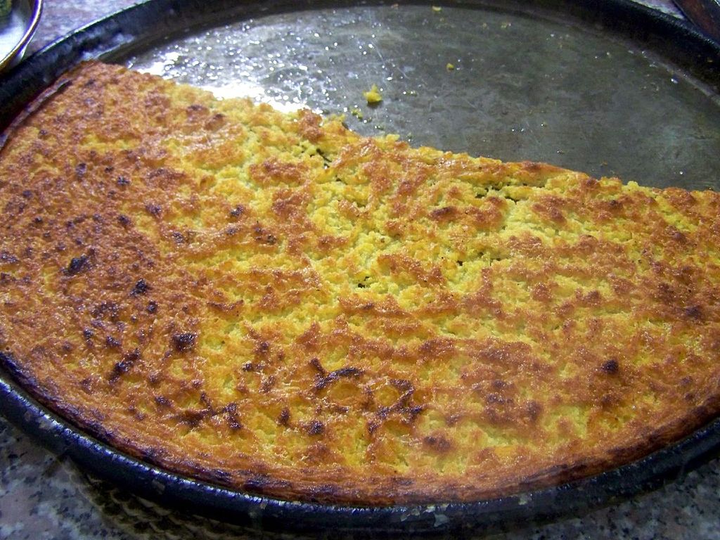 Close-up Photo of Farinata in a metal plate placed on a table