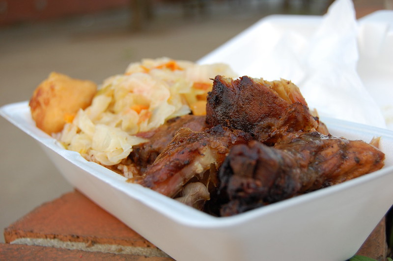 Close-up photo of jerk chicken in a white plastic bowl