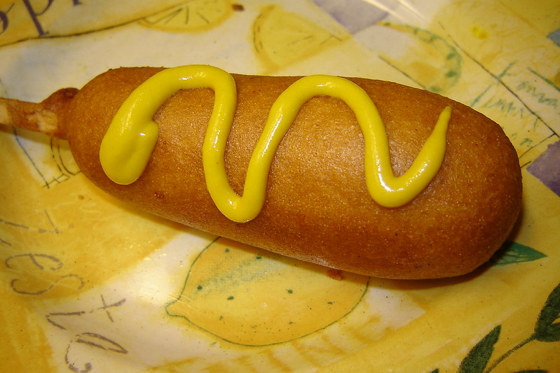 Close-up Photo of a Corn Dog with mustard placed