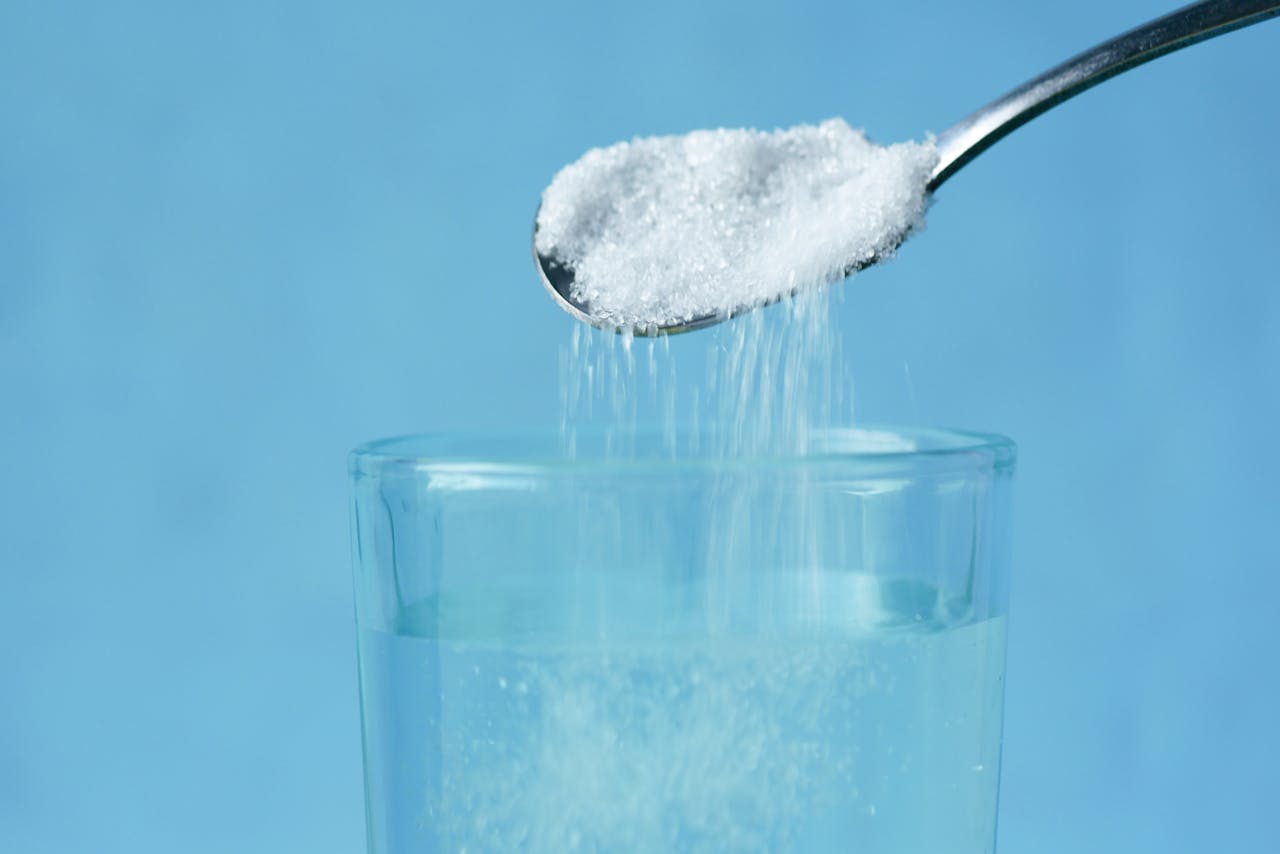 Pouring of White Sugar from Spoon