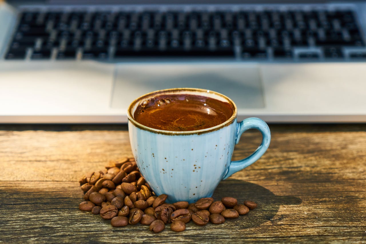 Close-Up Photo of Coffee Cup Beside Coffee Beans