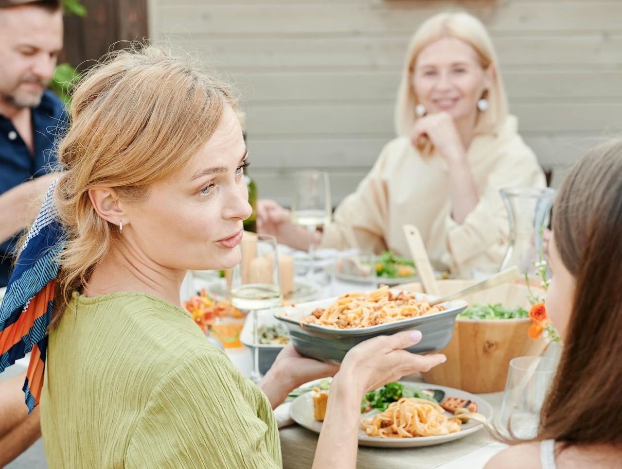 People eating macaroni salad outside.