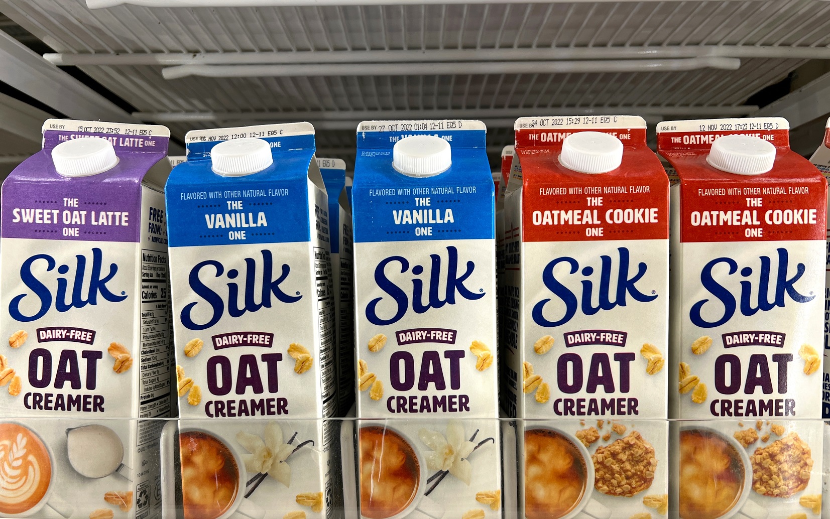 Grocery store shelf with cartons of Silk brand Dairy Free Oat creamers.
