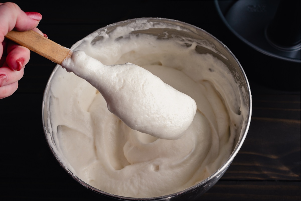 Hand Holding a Spatula with Freshly Mixed Angel Food Cake Batter