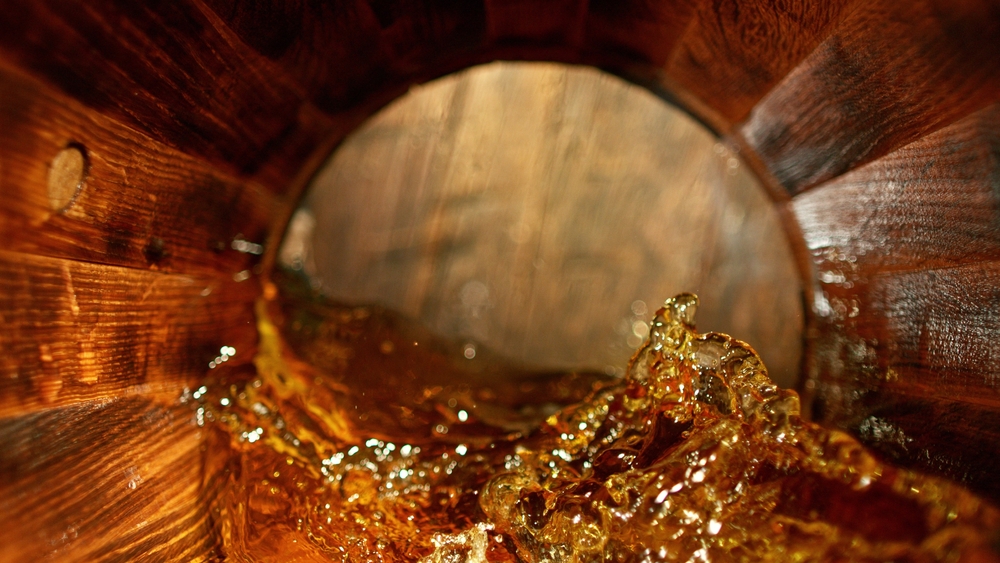 splashing whisky in wooden barrel
