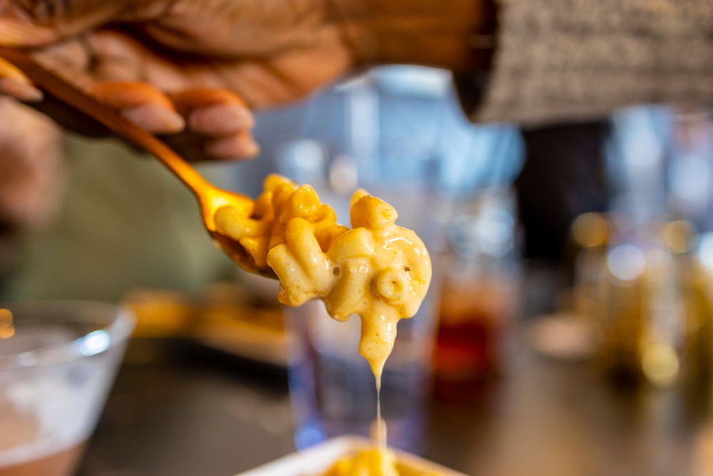 hand picking up delicious mac and cheese with a fork