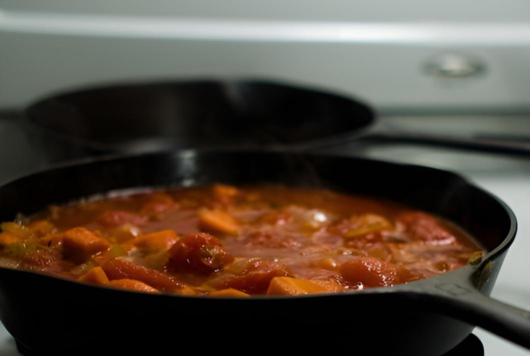 Close Up Photo of Black pan with tomato sauce placed on a stove