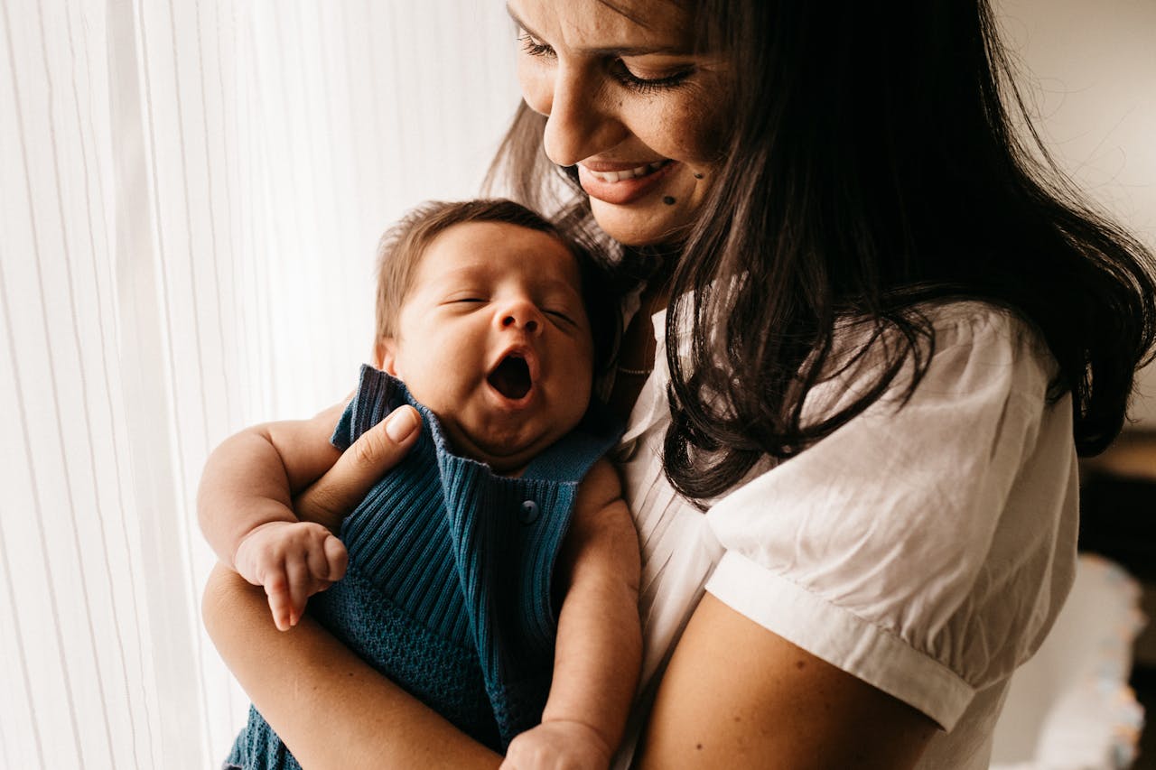 Photo of Smiling Mother Holding Her Cute Baby