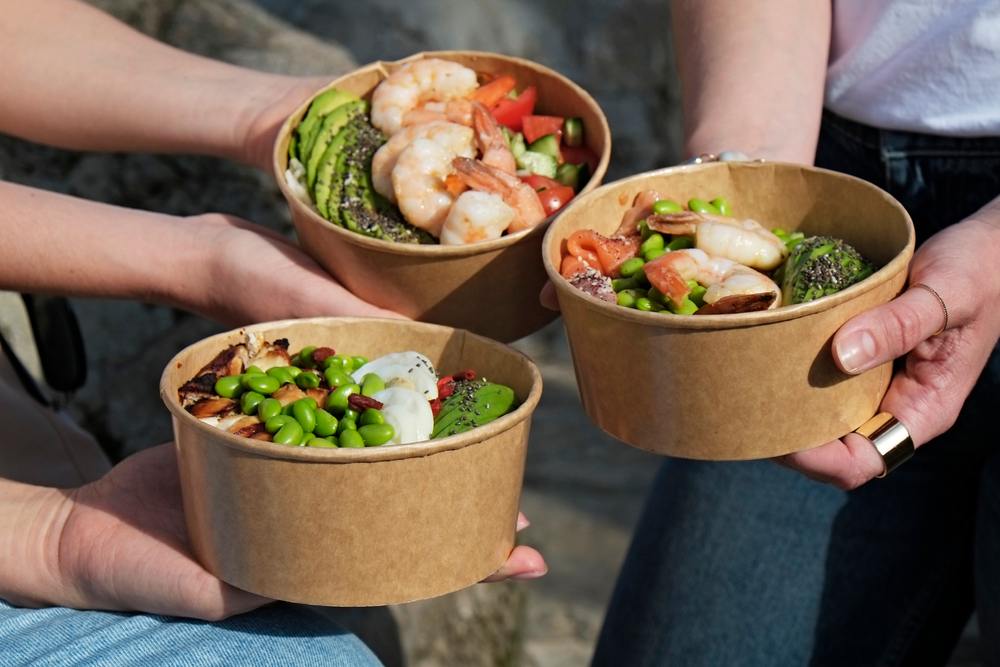 takeout bowls with fish and vegetable meals