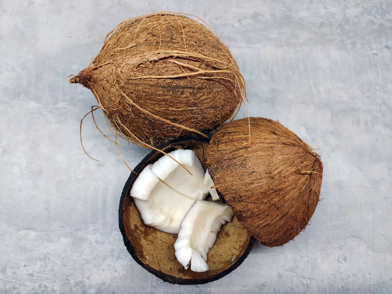 Photo of Broken Coconuts placed on a gray surface