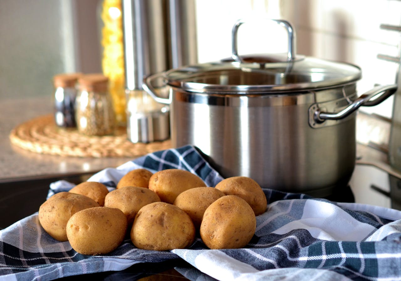Close Up Photo of Potatoes Beside Stainless Steel Cooking Pot