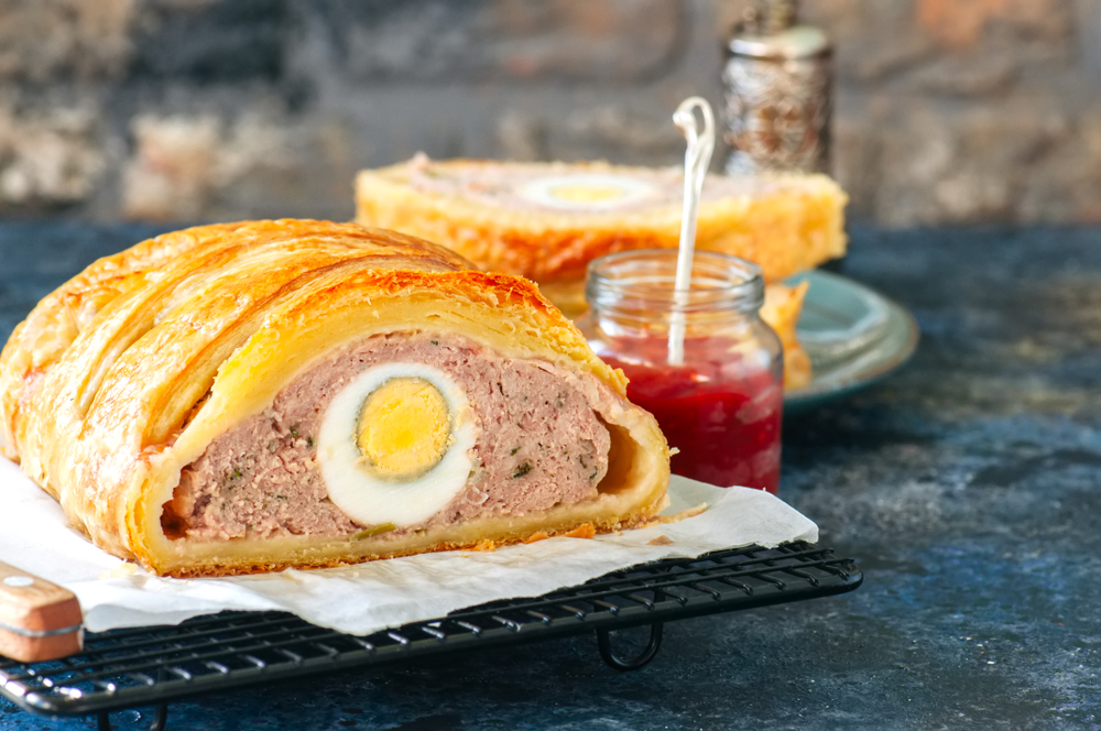 Meatloaf with egg filling in a puff pastry served on a wire rack.