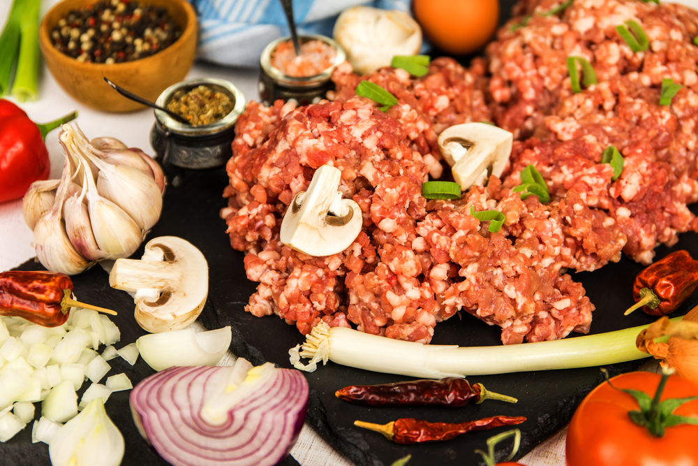 Freshly prepared meatloaf ready for the oven with ingredients.