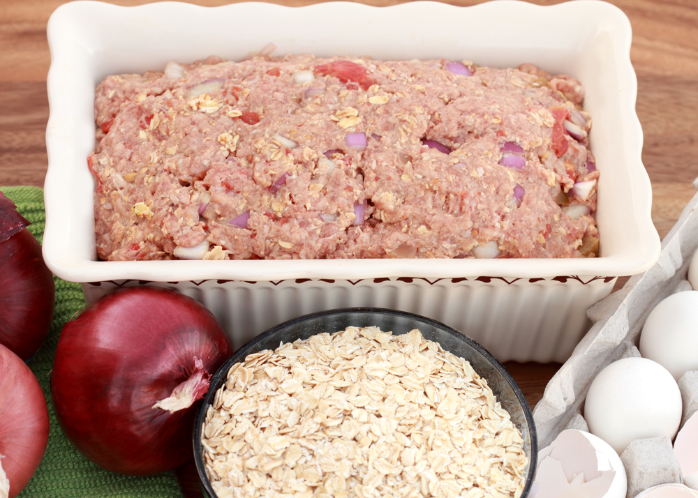 Freshly prepared meatloaf ready for the oven with ingredients.