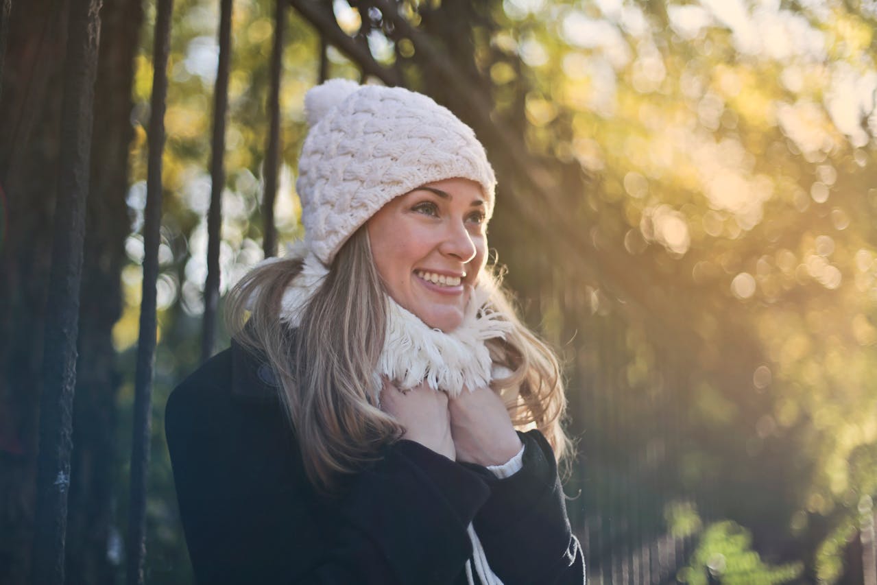 Photography of Woman in Black Jacket and White Knit Cap Smiling