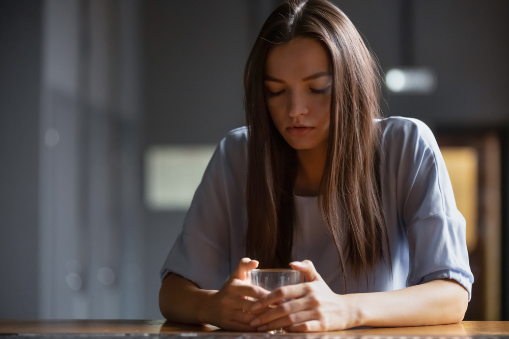 Lonely drunk woman sitting on bar counter feels depressed