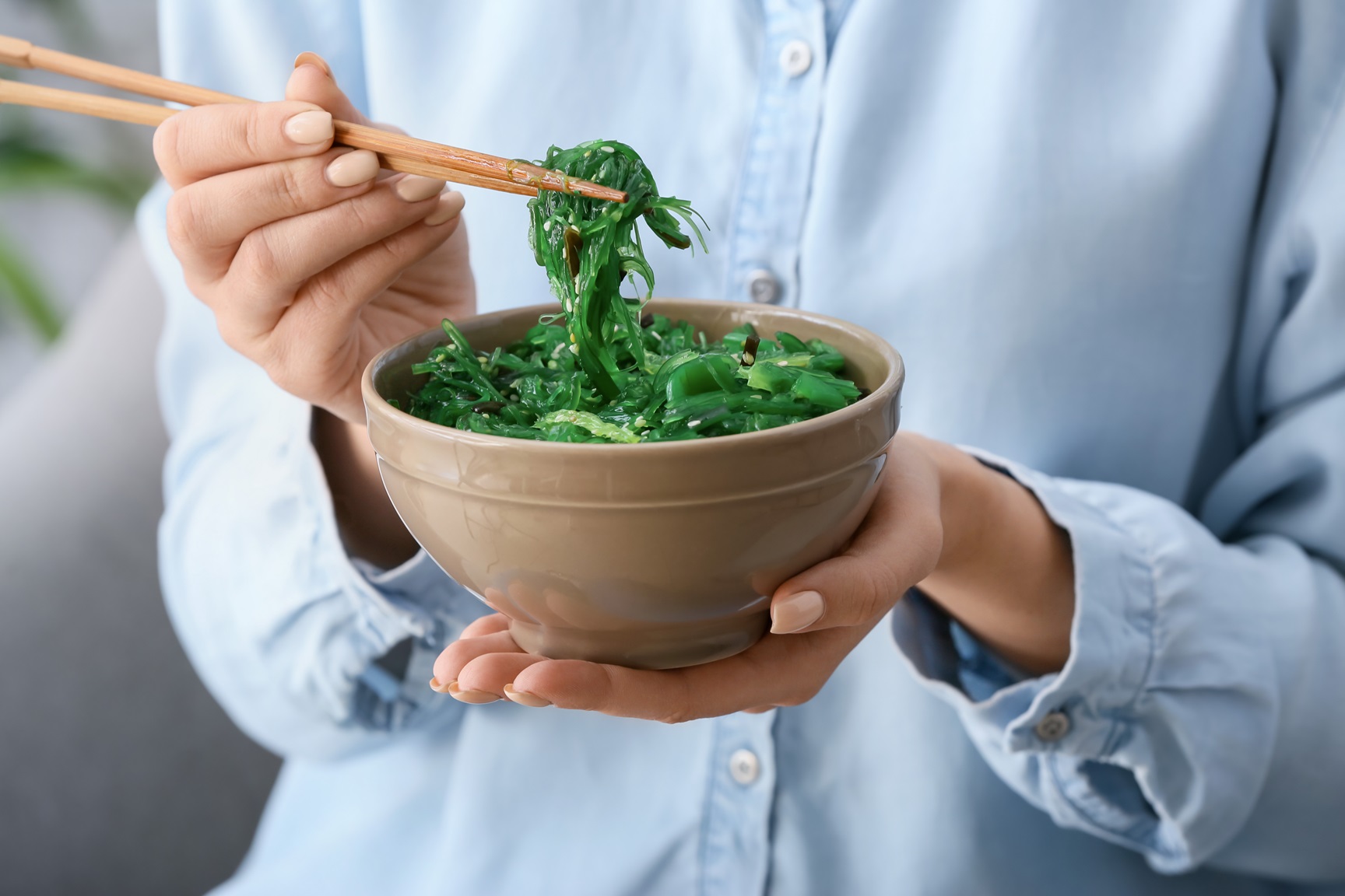 Woman eating tasty seaweed salad, closeup
