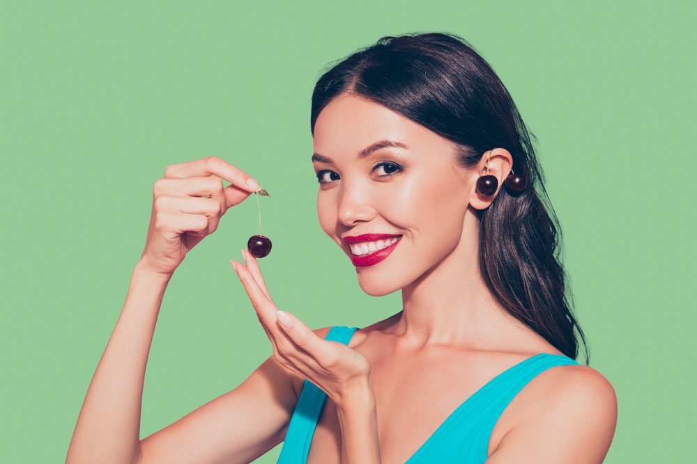 Close-up portrait of girl with ripe cherries