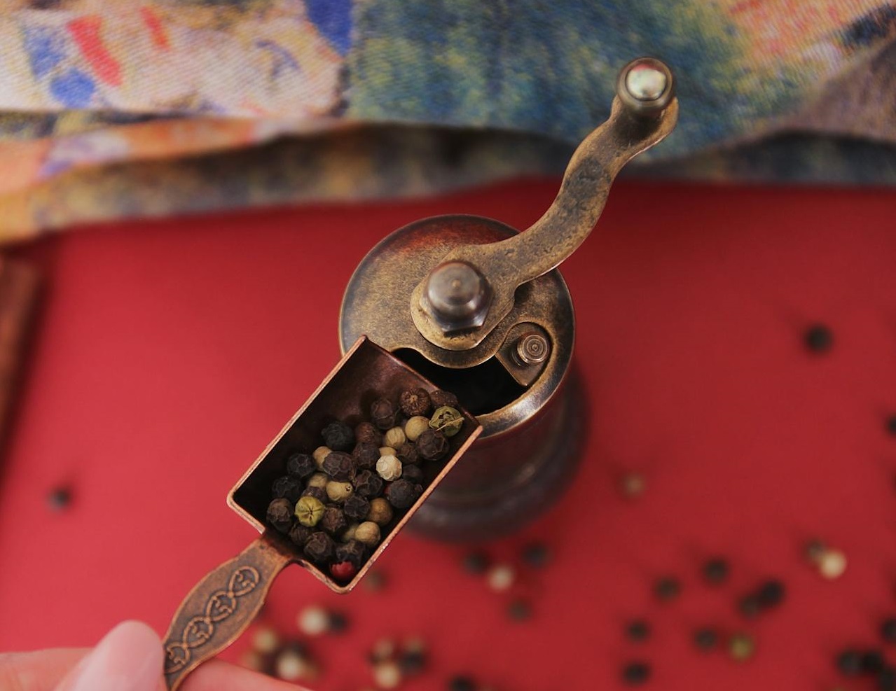 A Person Putting Peppercorns in a Grinder