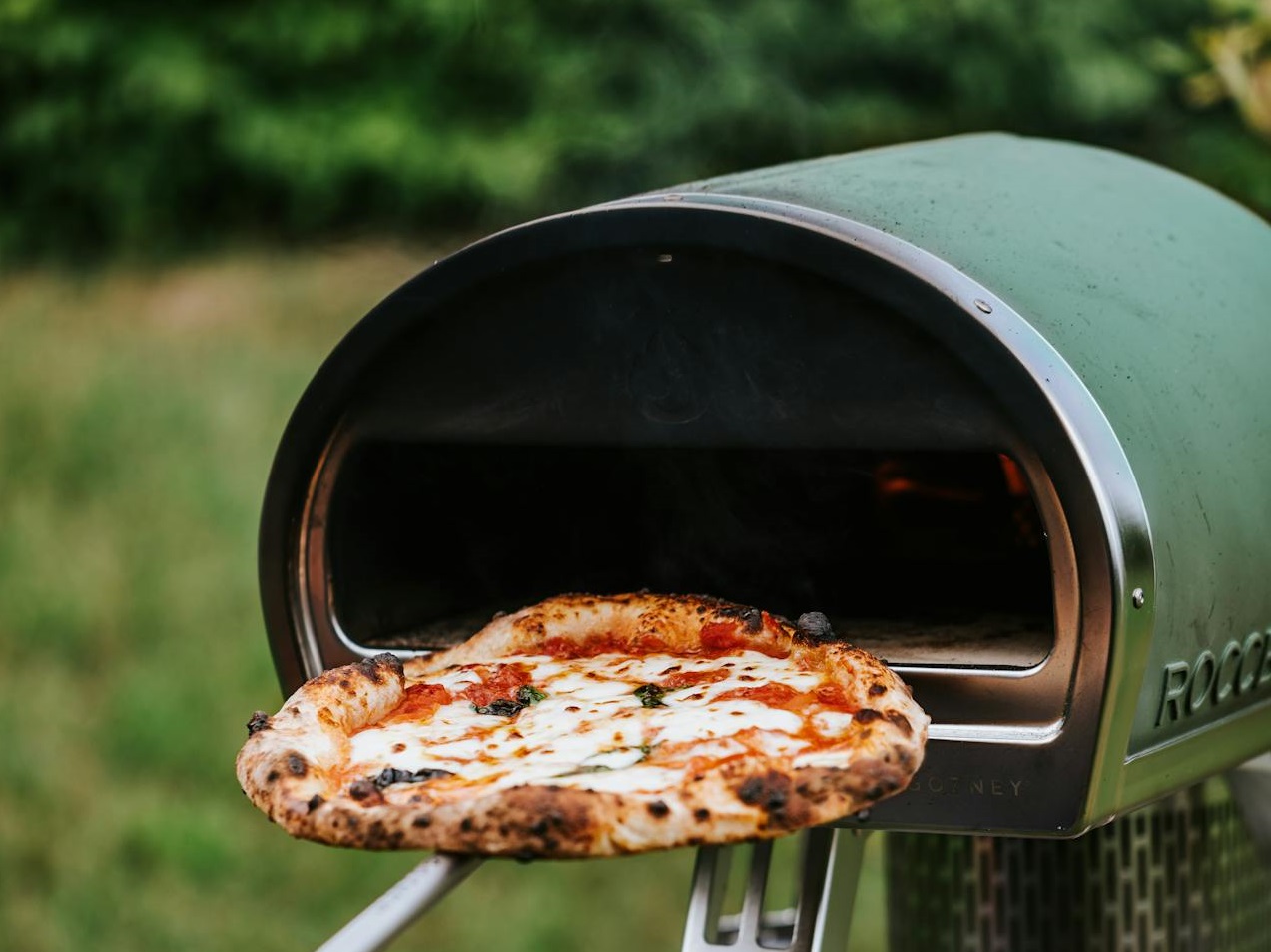Person Taking a Pizza out of the Oven