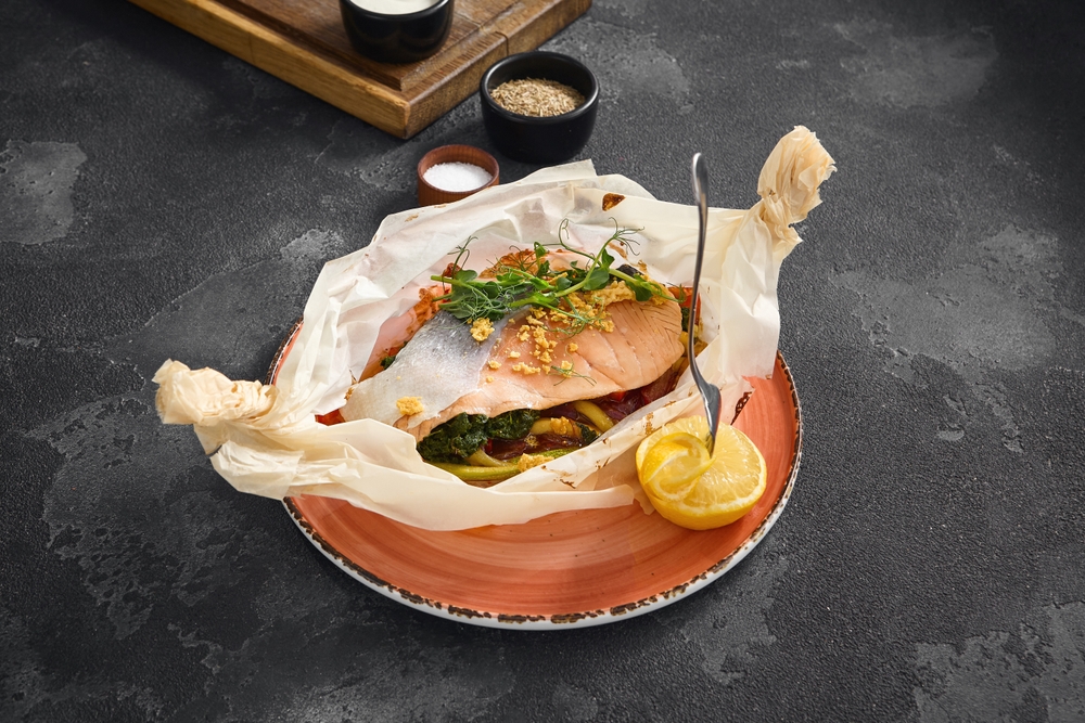 Freshly baked salmon steak in in parchment paper