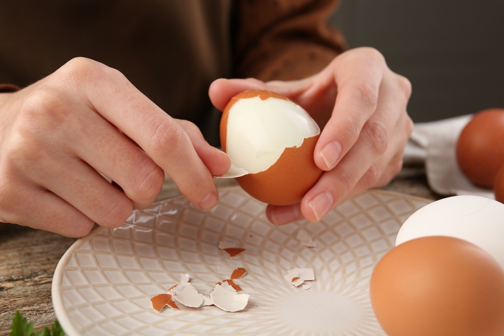 Woman peeling boiled egg