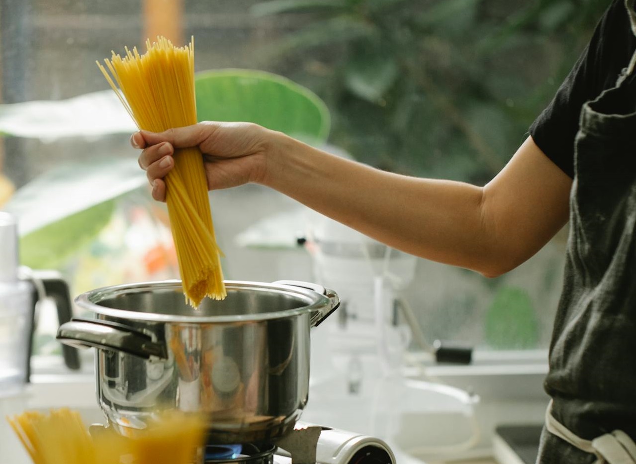 Housewife cooking pasta in modern kitchen