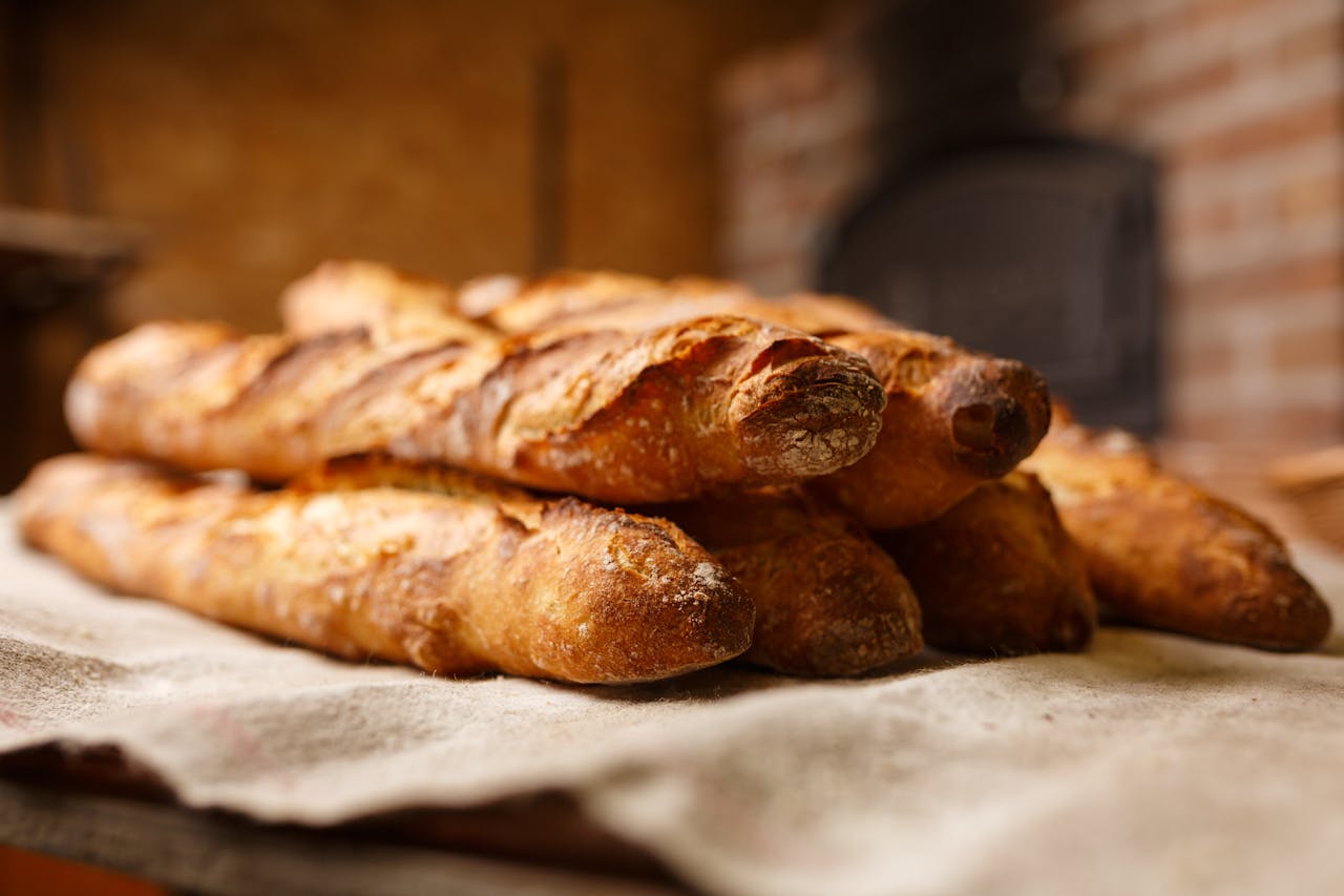 Close Up Photo of Six Baked baguettes placed on a wooden surface