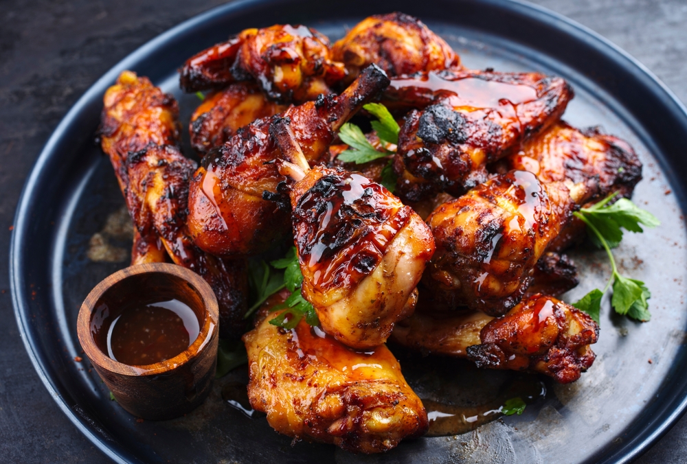 Traditional barbecue chicken wings and drumsticks with hot chili mango sauce