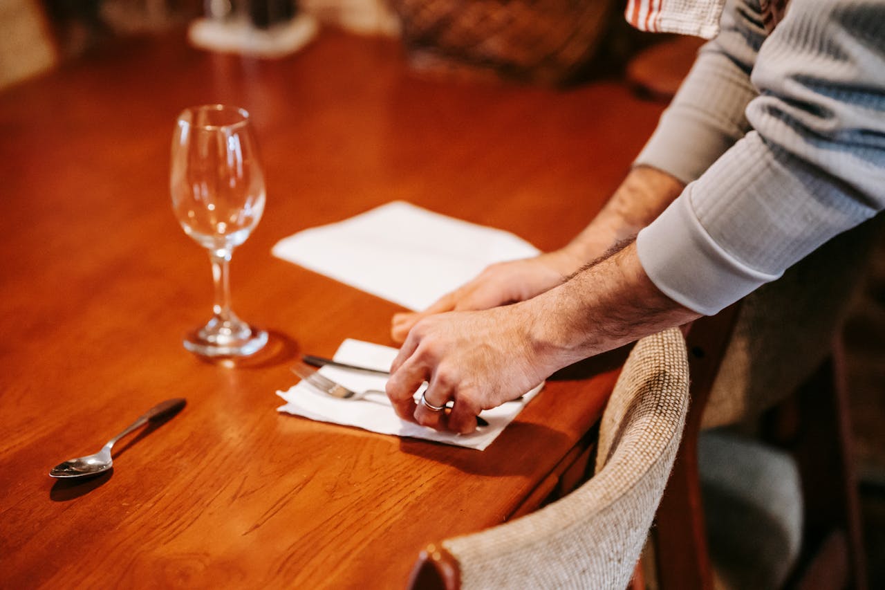 Close Up Photo of Faceless man serving table at home
