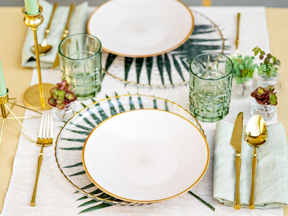 Sophisticated floral table setting. white crockery, golden cutlery and white table linen make a luxury setting.
