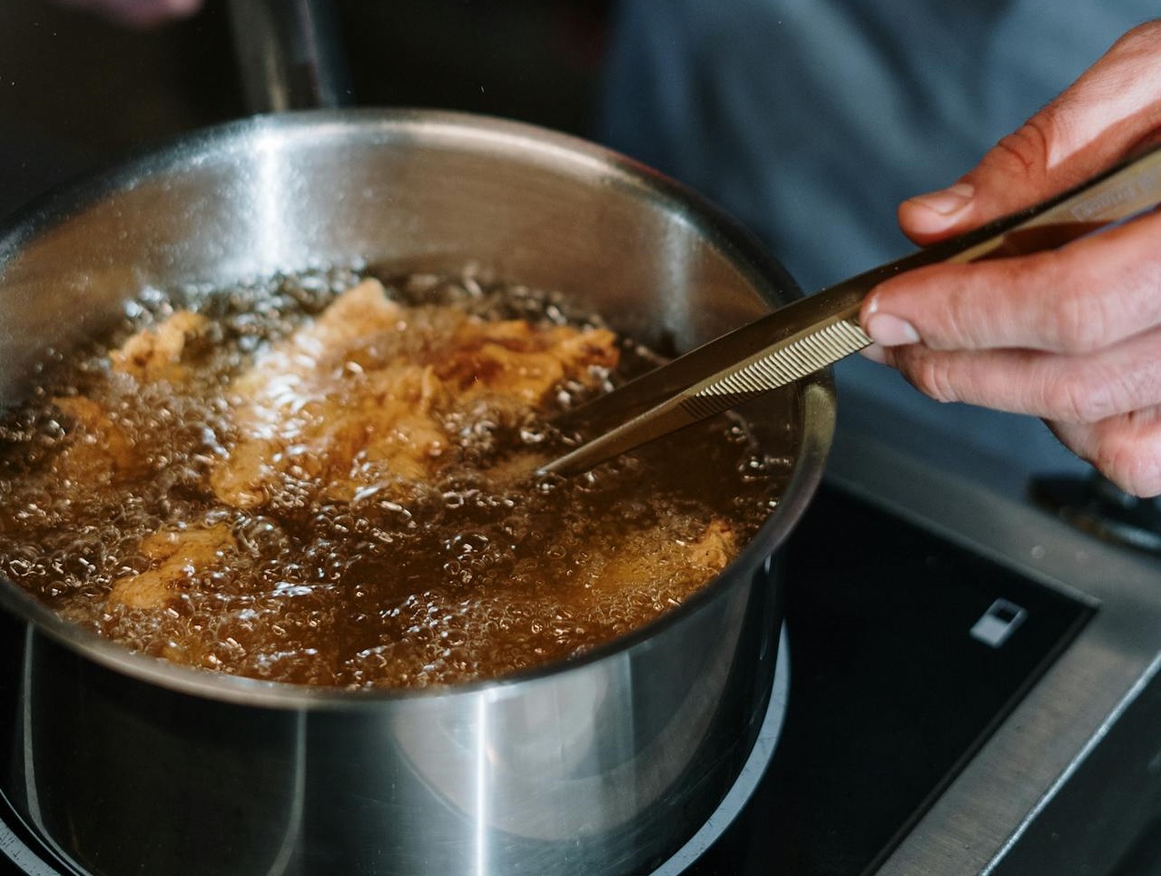 Person Holding Stainless Steel Cooking Pot
