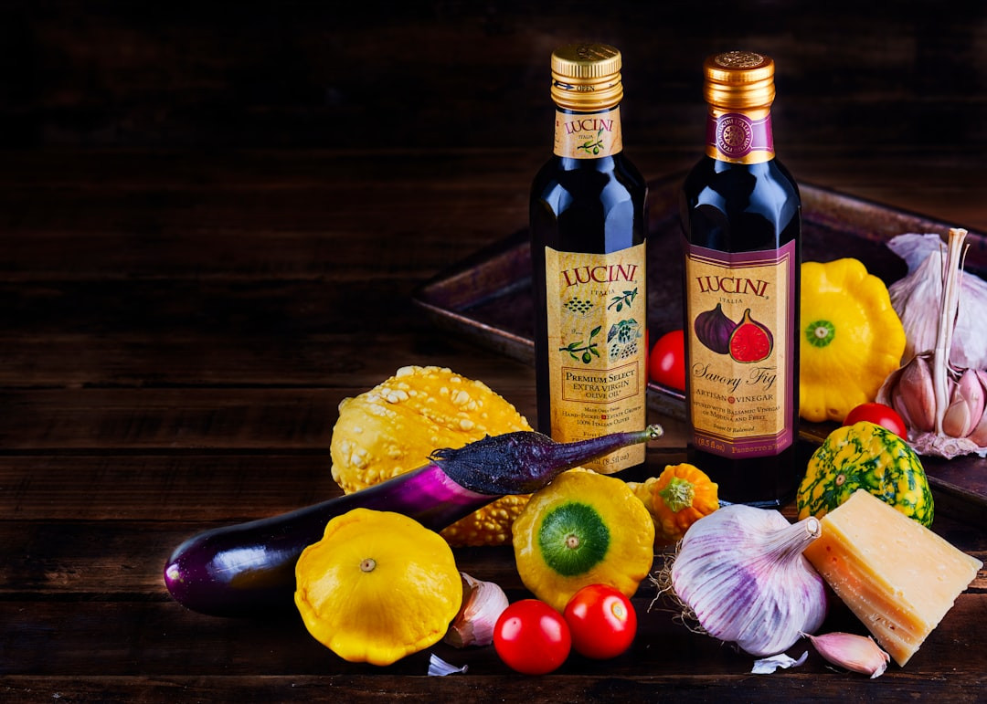 yellow labeled bottle beside red apple and yellow lemon fruit