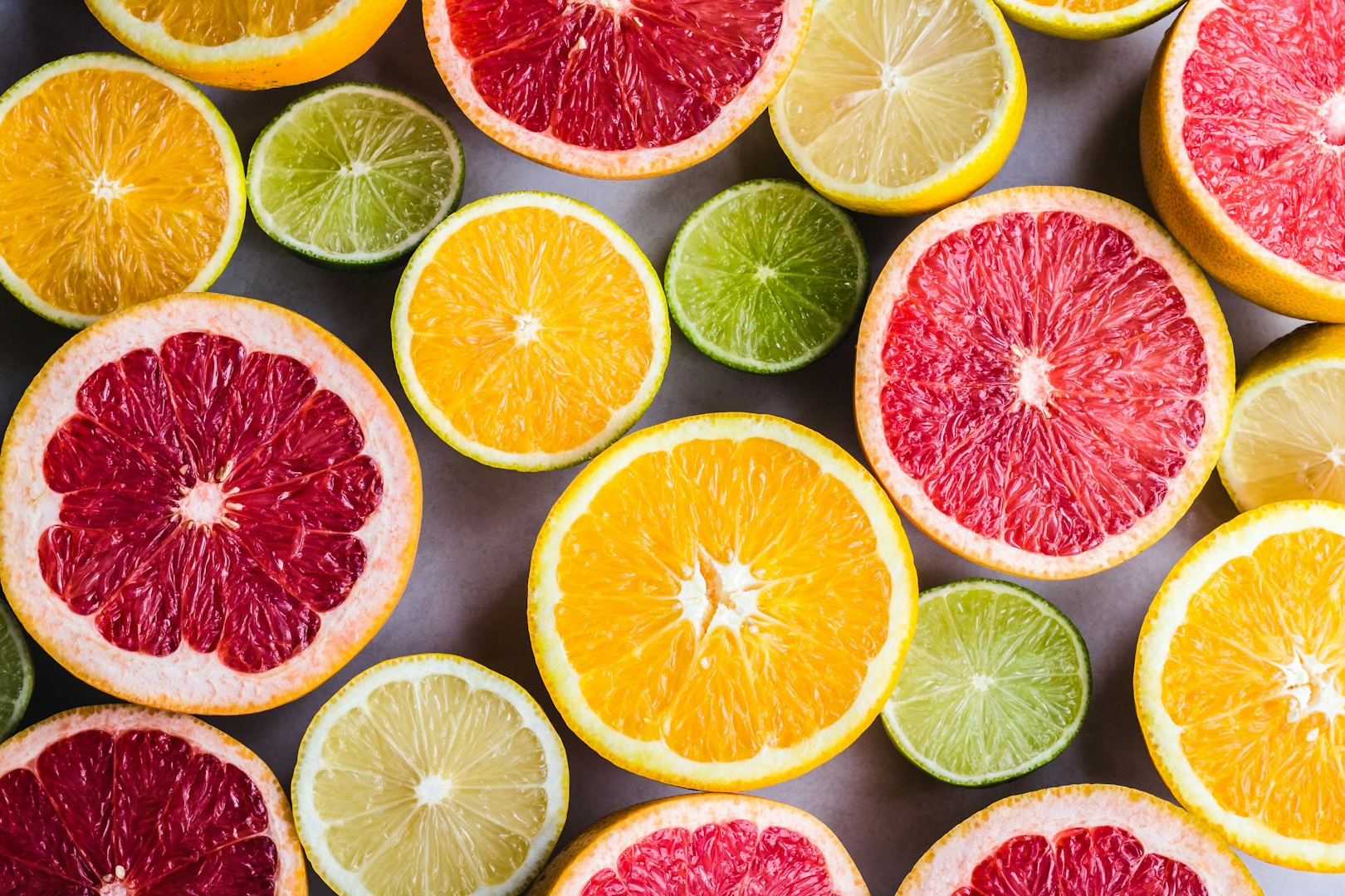 flat lay photography of sliced pomegranate, lime, and lemon