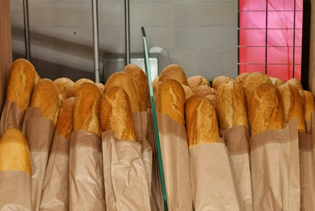 a bunch of baguettes that are sitting on a shelf