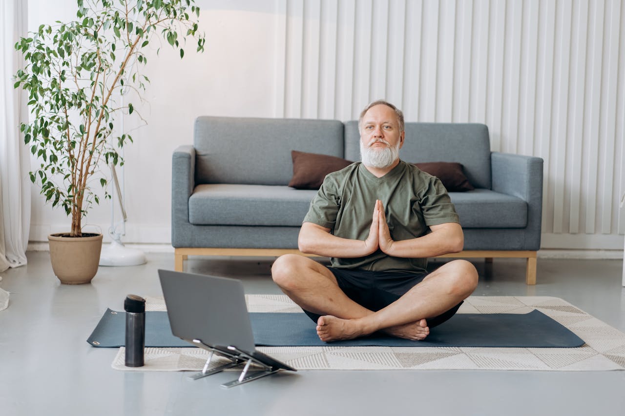 Photo of Man in Green T-shirt and Black shorts on Sitting on Floor Meditating