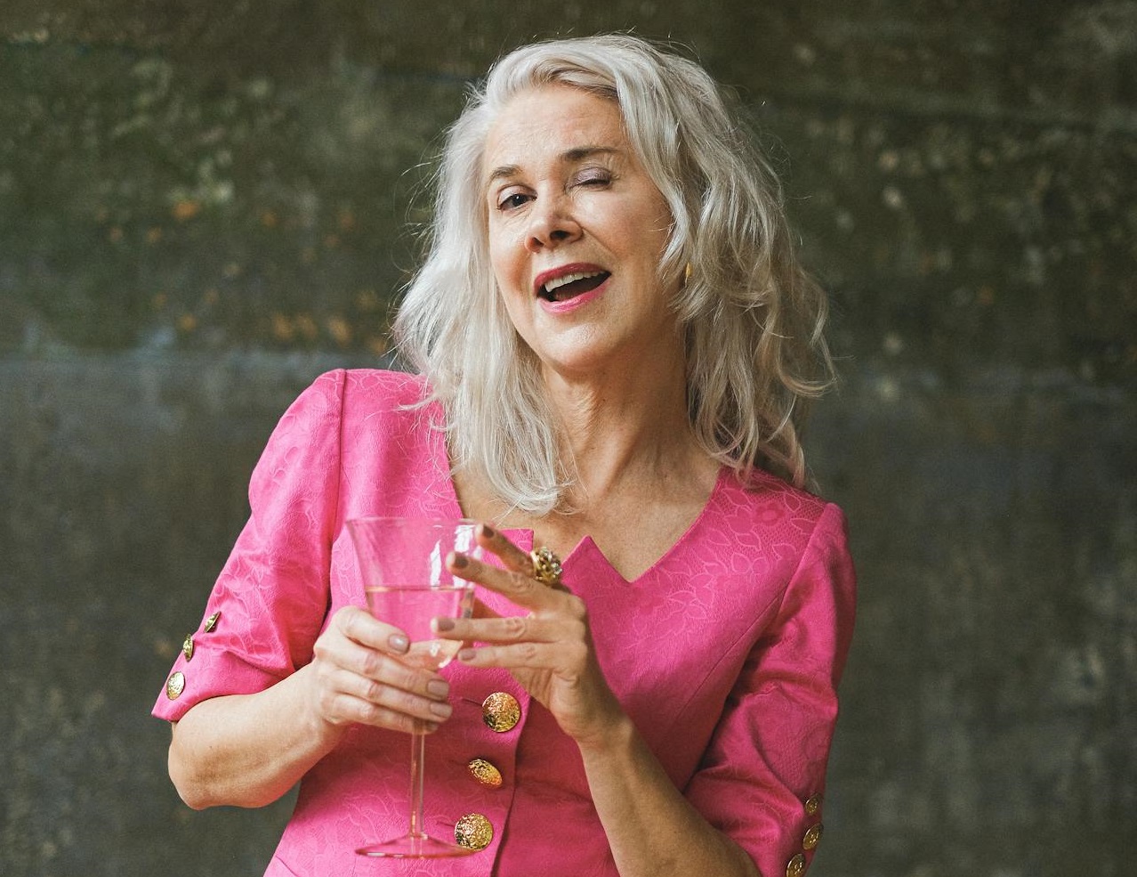 Senior woman with gray hair winking.