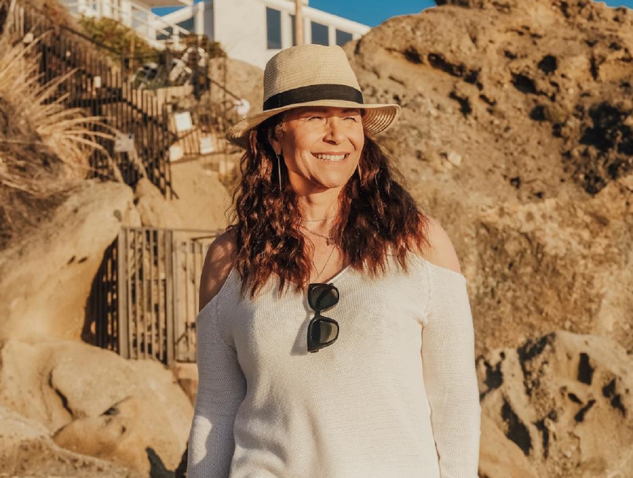 Senior Woman is Smiling while Walking on the Beach.