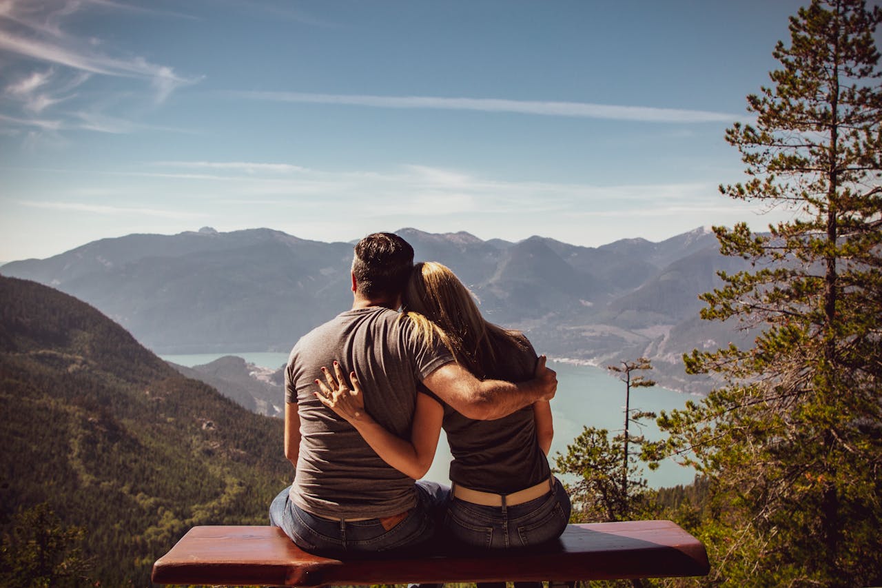 Man and Woman Sitting on Bench at woods.