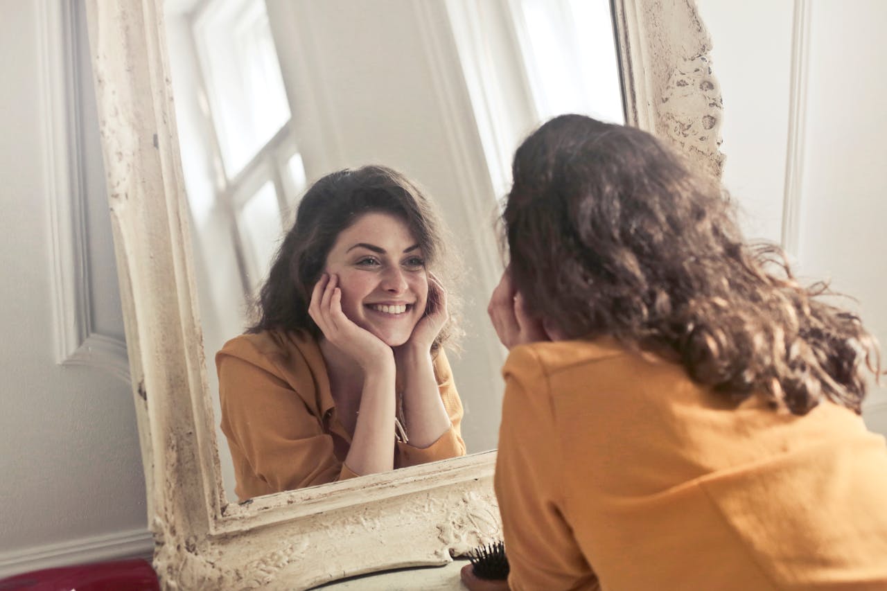 Happy Woman Looking at the Mirror and smiling.