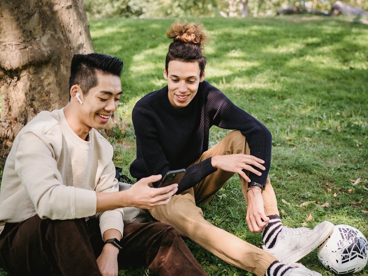 Two young men watching videos on smartphone.