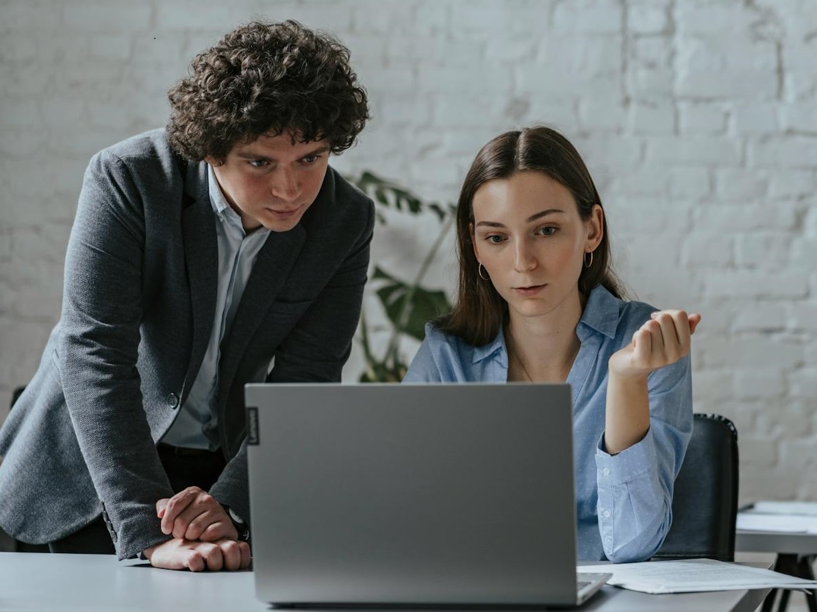 A Man and a Woman using Laptop while Working Together