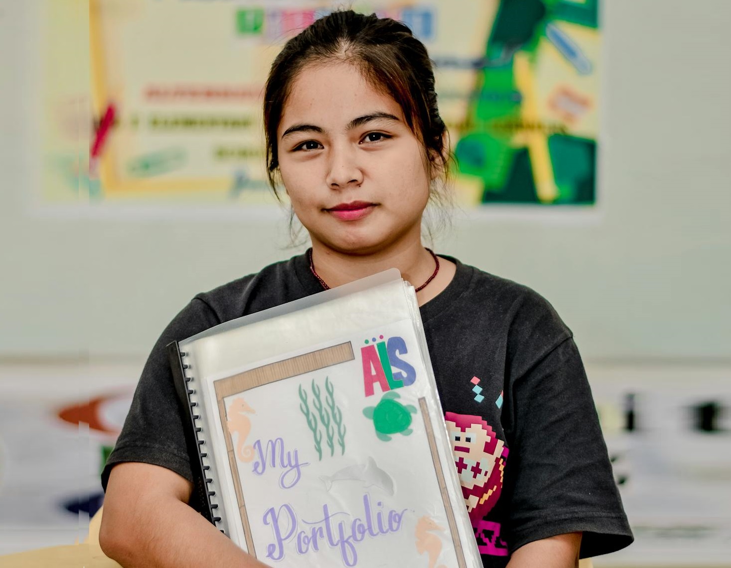 Young woman holding portfolio in hands.