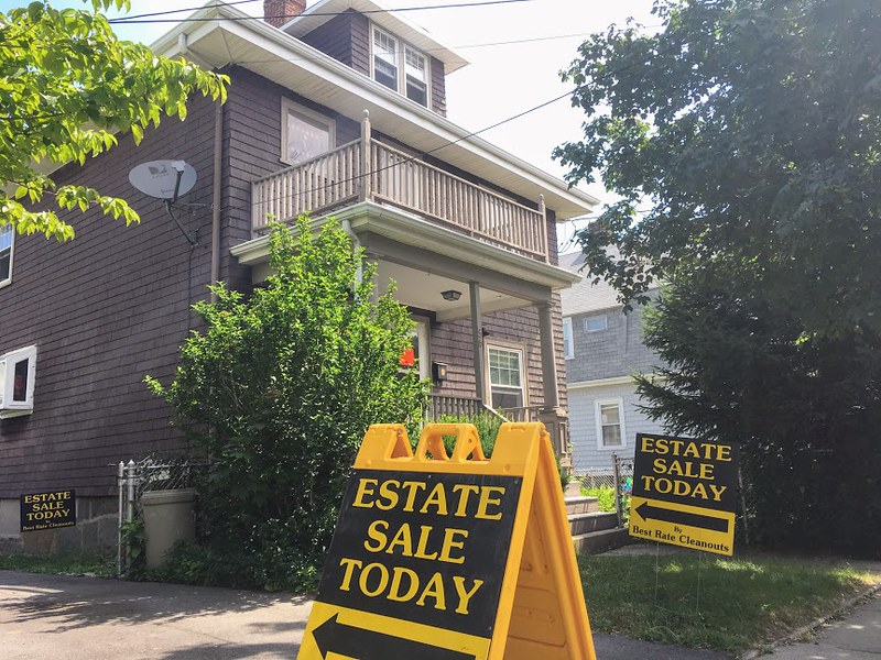 Photo of a House with estate sale sign in driveway