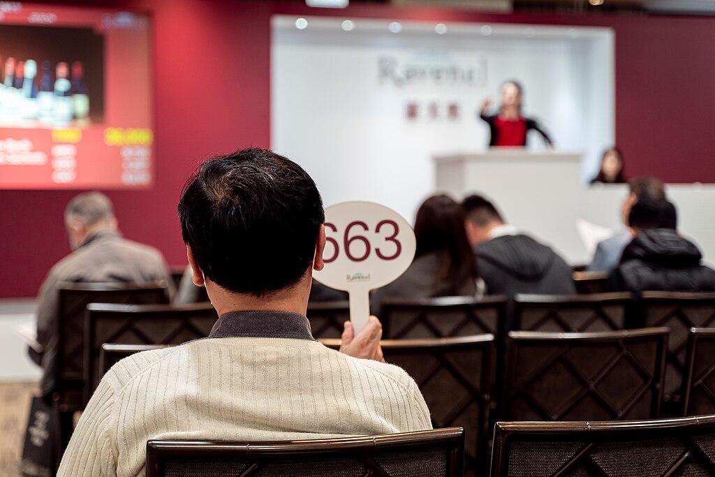 Close-up photo of a man holding a number sign on auction