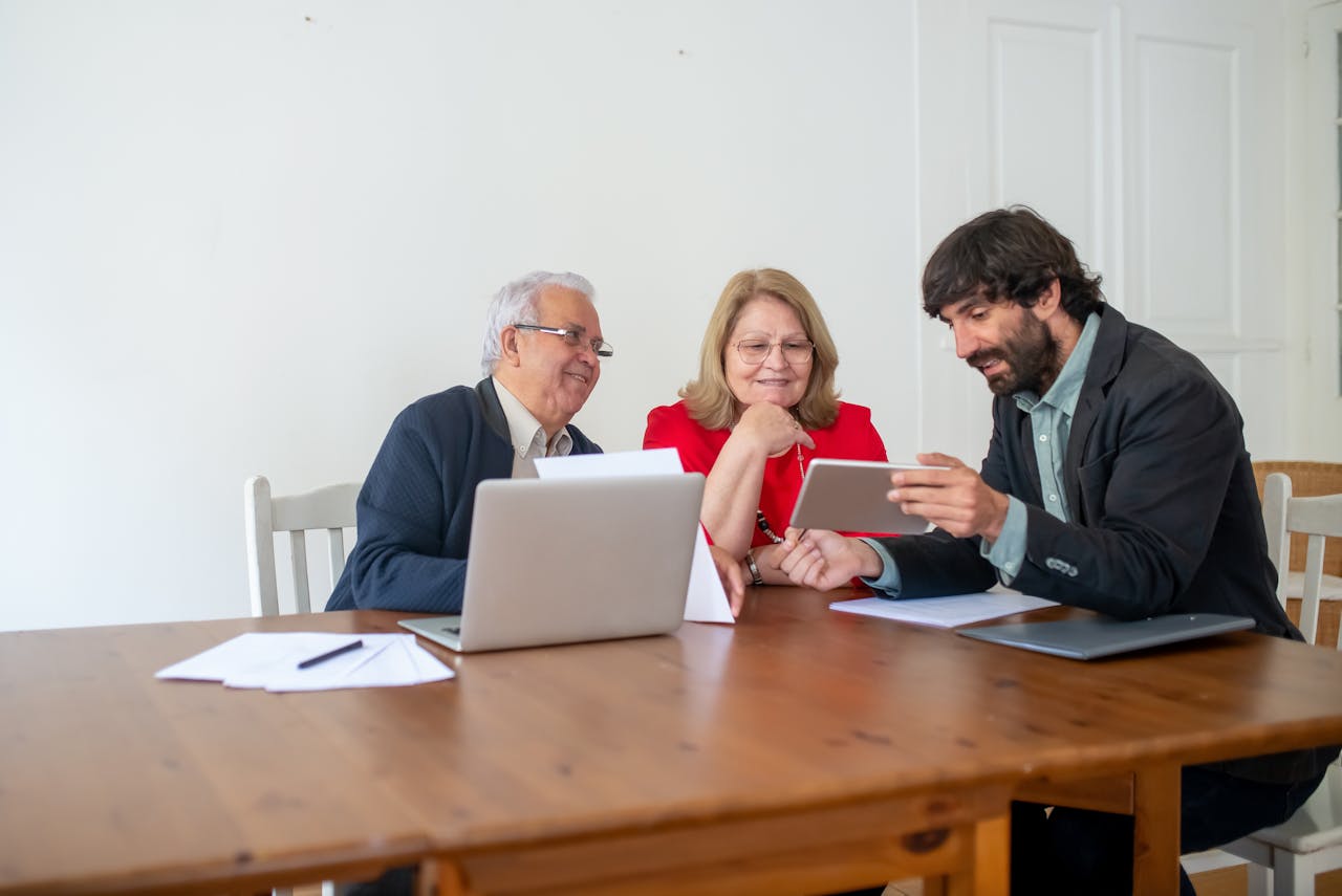 Group of People Sitting by the Wooden Table Discussing and smiling