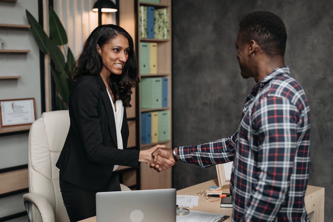 Female Liquidator and Client doing a Handshake  and smiling in an office
