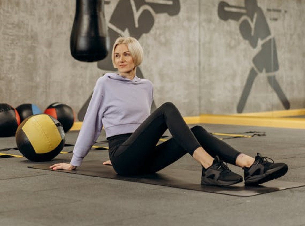 Woman Lying On A Mat Beside An Exercise Ball