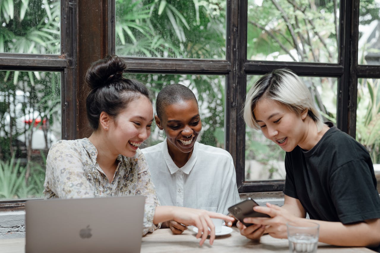 Happy multiethnic women having fun while using technology